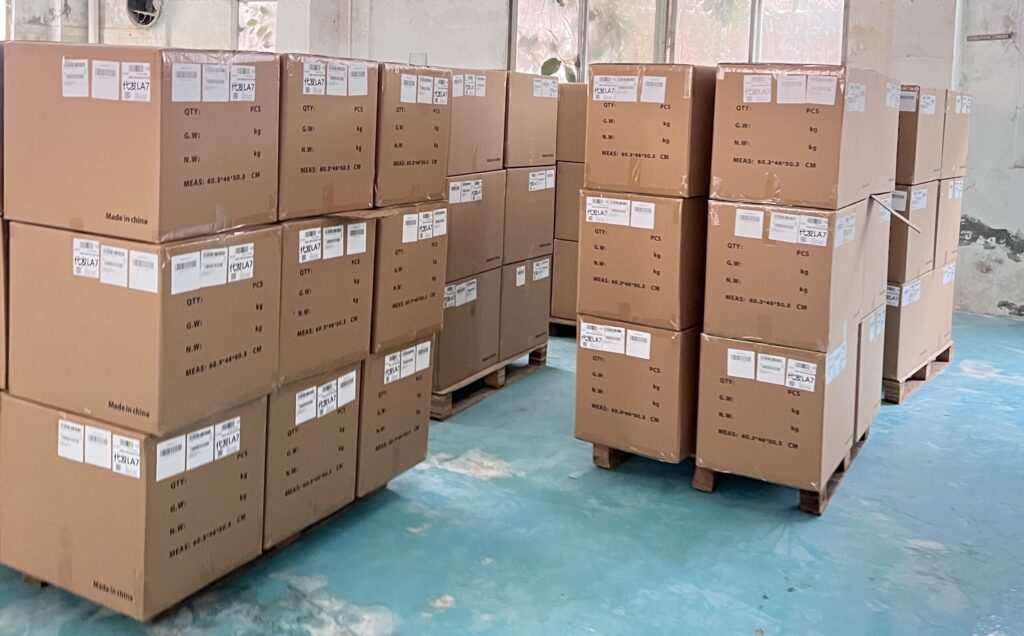 Pickleball paddle production workshop showing large batches of custom carbon fiber paddles in multiple colors, ready for assembly and packaging from a professional manufacturing factory