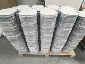 Thermoformed carbon fiber pickleball paddles in bulk production inside a professional paddle manufacturing factory