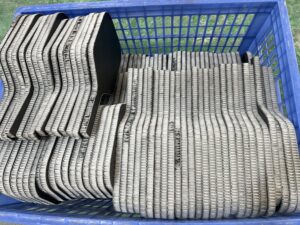 Cold-press pickleball paddle production workshop with CNC cutting machines and stacked raw paddle sheets, showing industrial manufacturing of composite paddles