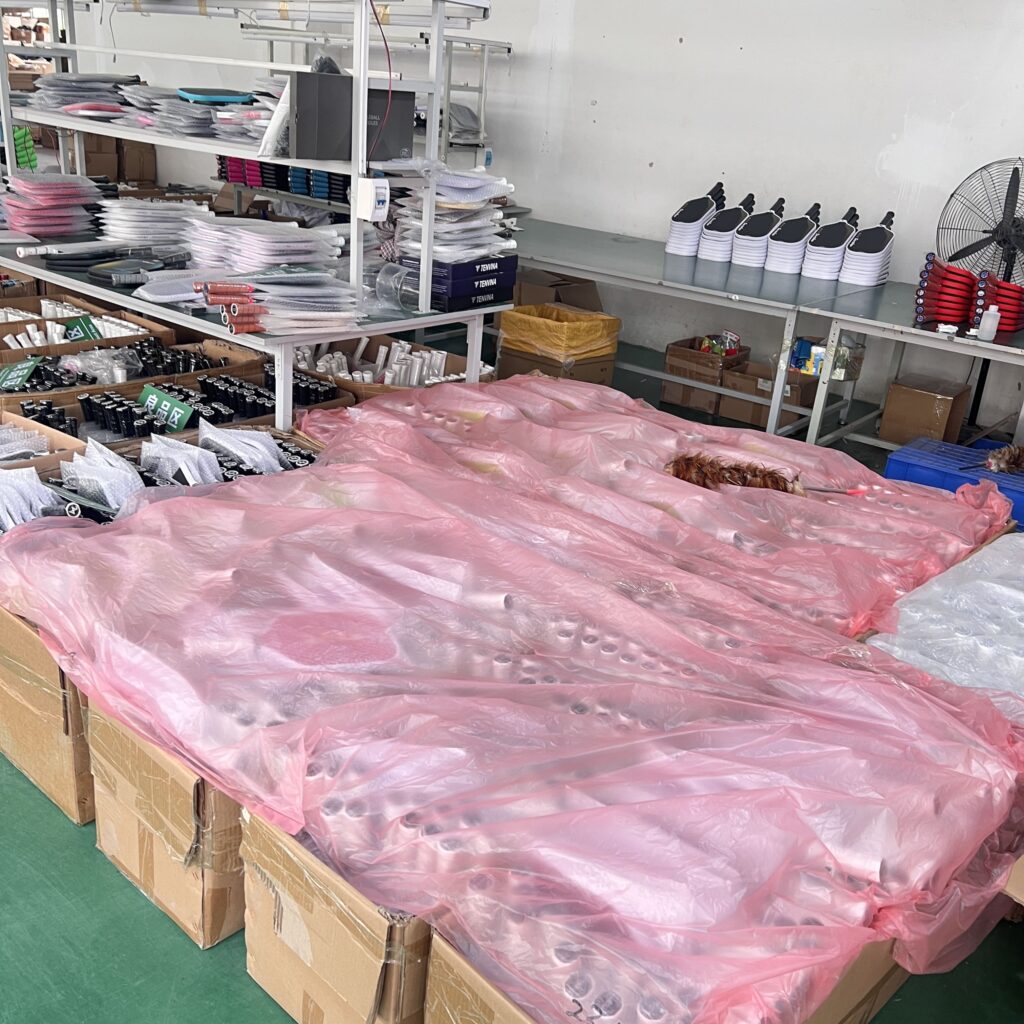 Pickleball paddle production workshop showing large batches of custom carbon fiber paddles in multiple colors, ready for assembly and packaging from a professional manufacturing factory
